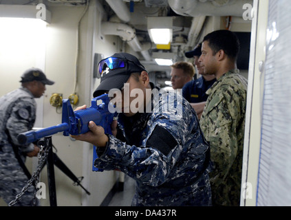 Un miembro de la Guardia Costera de Filipinas asegura un corredor durante una visita, junta, búsqueda e incautación evento de capacitación celebrado en su Foto de stock