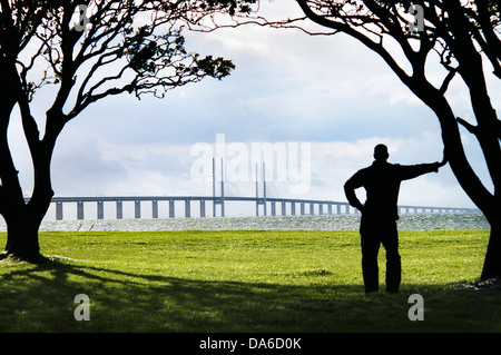 Silueta de hombre mirando desde la distancia del puente de Oresund