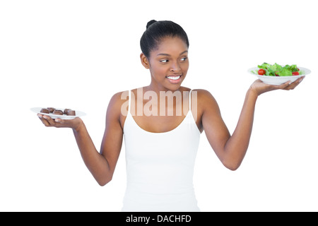 Mujer alegre decidir comer sanamente o no Foto de stock