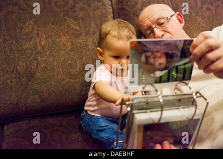 Abuelo y nieta de bebé mirando el álbum de fotos