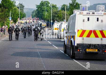 Belfast, Irlanda del Norte, 12 de julio de 2013 - PSNI oficiales vestidos de antidisturbios ejecutar una carretera seguida por vehículos blindados Landrovers Crédito: Stephen Barnes/Alamy Live News Foto de stock