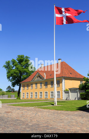 Bandera danesa por 18thc Commander's House 1725 en Kastellet o Frederikshavn Ciudadela fortificada en Copenhague, Zelanda, Dinamarca Foto de stock