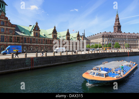 Los turistas canal excursión en barco por el antiguo edificio de la Bolsa y Borsen Christiansborg Palace en Copenhague, Dinamarca