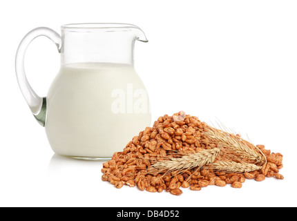 Copos de cereales, trigo, orejas y jarra de cristal con leche sobre fondo blanco. Foto de stock