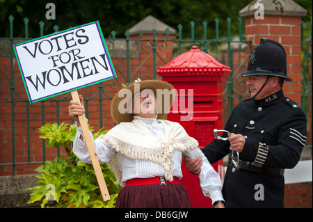 Mujer suffragette demostrando con etiqueta de ser arrestado en protesta por un policía con esposas Foto de stock