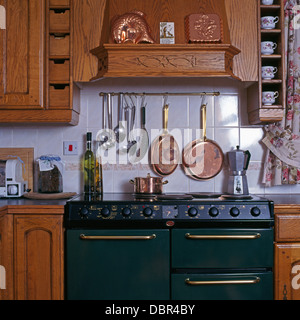 Utensilios de cocina y sartenes de cobre en la rampa por encima de la gama  verde de microondas con cafetera italiana en casa cocina Fotografía de  stock - Alamy