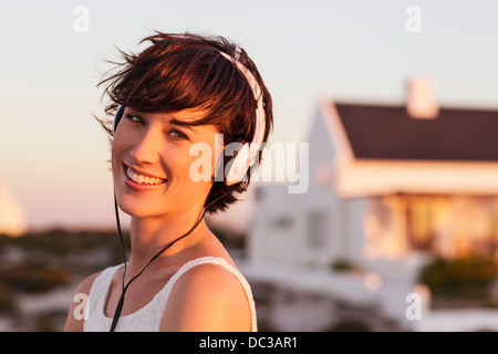 Retrato de mujer sonriente usando audífonos Foto de stock