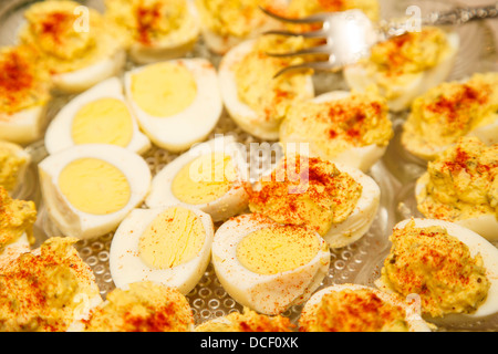Huevos deviled tradicional aderezado con paprika en un plato de cristal
