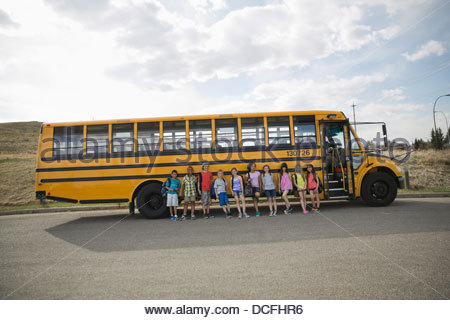 Grupo de niños de pie contra el autobús escolar