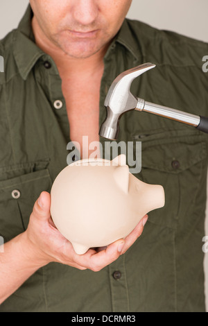 Un frustrado empresario rompe su martillo grande en una hucha grande y  sólido Fotografía de stock - Alamy