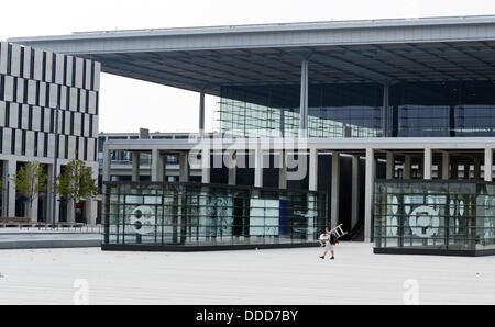 Un trabajador camina con una escalera pasado del edificio del aeropuerto del aeropuerto Berlín-Brandenburgo Willy Brandt BER en la Willy-Brandt-Platz en schoenefeld, Alemania, el 30 de agosto de 2013. Foto: JENS KALAENE Foto de stock