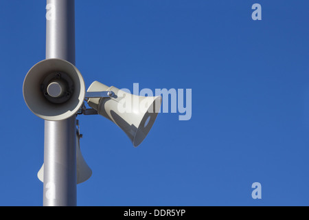 Tres megáfonos montado en un poste de plata sobre el cielo azul Foto de stock