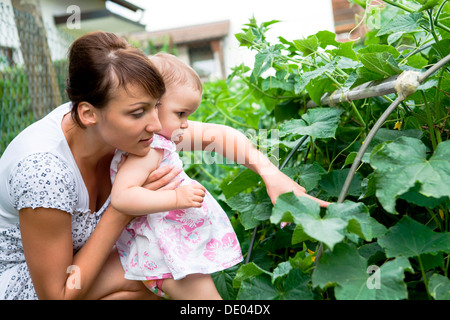 Una joven madre con su hija en un jardín. Foto de stock