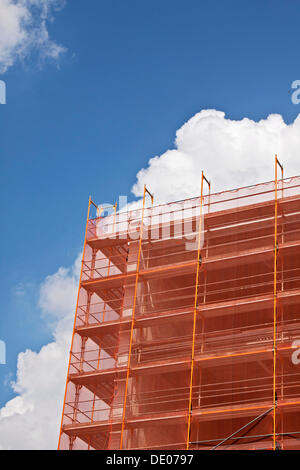 Andamios con orange redes protectoras en un sitio de construcción de gran altura Foto de stock