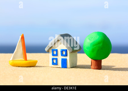 Modelo de casa de plastilina, árbol y barco por la costa Fotografía de  stock - Alamy