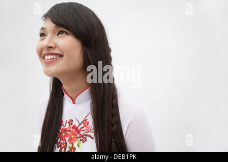 Retrato de mujer sonriente con cabello largo vistiendo un traje tradicional de Vietnam, Foto de estudio Foto de stock