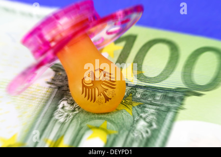 Maniquí con águila federal y cien euros, dinero, cuidado fotográfico simbólico Schnuller mit Bundesadler und Hundert-Euro-Schein, S Foto de stock