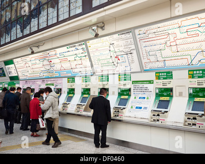 Multitud de gente compra billetes de tren en máquinas expendedoras en la estación JR Ueno, en Tokio, Japón. Foto de stock