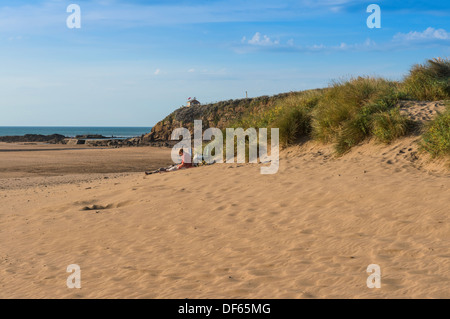 Bude, Cornwall, Inglaterra. El 27 de septiembre de 2013. Una pareja de mediana edad relajarse en la playa Summerleaze junto a las dunas. Foto de stock