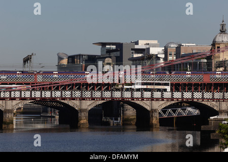 Vista al oeste para ferrocarriles, carreteras y puentes peatonales sobre el río Clyde en el centro de la ciudad de Glasgow, Escocia, Reino Unido Foto de stock