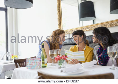 Tarjeta de felicitación con amigas sentados en la mesa de restaurante