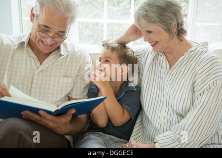 Los abuelos mostrando boy photo album en el sofá