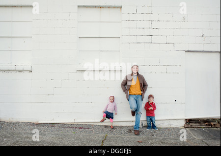 Mitad hombre adulto y su hijo e hija recostada contra la pared, Retrato