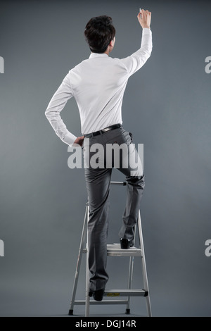 Un hombre de negocios en una escalera Foto de stock