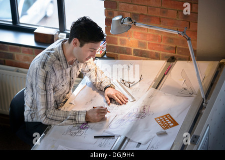 Dibujo de planos de arquitecto al tablero de dibujo