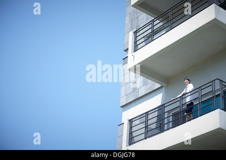 Un hombre de pie sobre un balcón Foto de stock