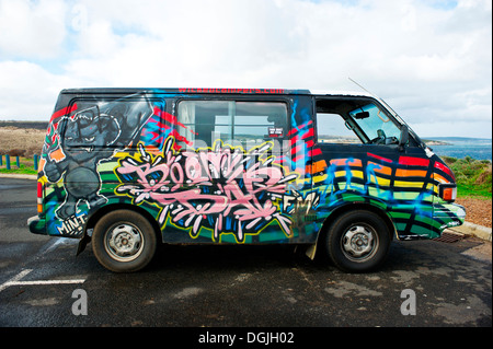 Un Volkswagen camper van cubiertos de coloridos diseños.