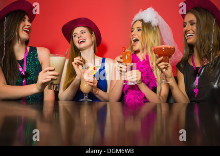Amigos riendo en una gallina noche bebiendo cócteles Foto de stock