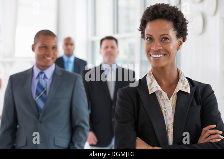 La gente de negocios. Un equipo de personas, un departamento o una empresa. Tres hombres y una mujer. Foto de stock