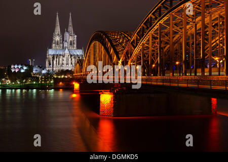 Puente Hohenzollern sobre el Rin, la catedral de Colonia y de la Filarmónica de Colonia, en la noche, Colonia, Renania Foto de stock