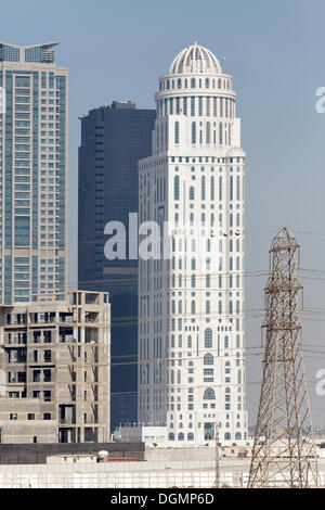 Rascacielos y un sitio de construcción interrumpida con el edificio de la concha, el Jumeirah Lake Towers, Dubai, Emiratos Árabes Unidos. Foto de stock