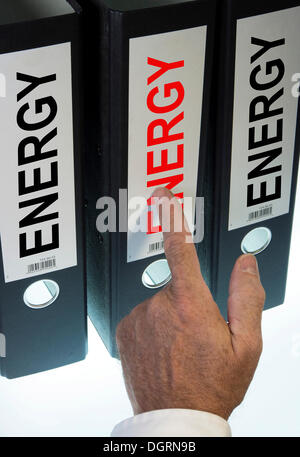 Mano apuntando a una carpeta de anillas etiquetado energético, imagen simbólica Foto de stock