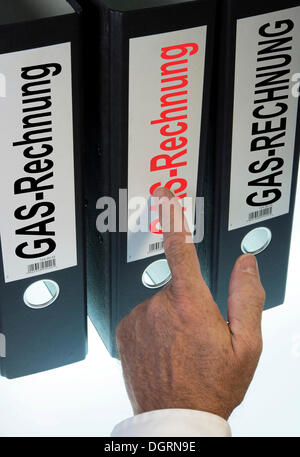 Mano apuntando a una carpeta de anillas etiquetada Gasrechnung, Alemán para la factura del gas, imagen simbólica Foto de stock