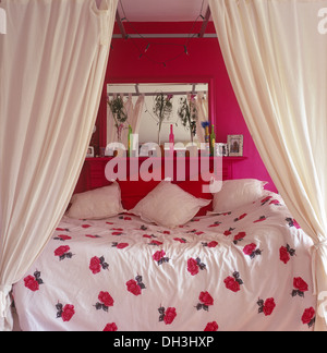 Cortinas blancas encima de una cama individual con ropa de cama blanca y  cojines en dormitorio tradicional con imágenes grandes y telas ciegos  Fotografía de stock - Alamy