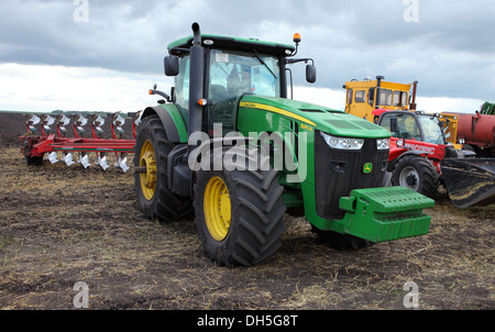 Tractor John Deere con un arado preparatorio para arar en otoño Foto de stock