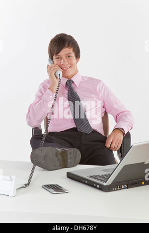 Empresario joven hablando por un teléfono en una oficina. Foto de stock