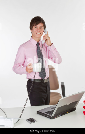 Joven Empresario de hablar por teléfono en la oficina Foto de stock