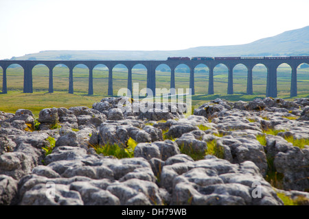 Tren de vapor cruzando Ribblehead Viaduct con pavimento de piedra caliza en primer plano. Yorkshire Dales National Park North Yorkshire, Reino Unido