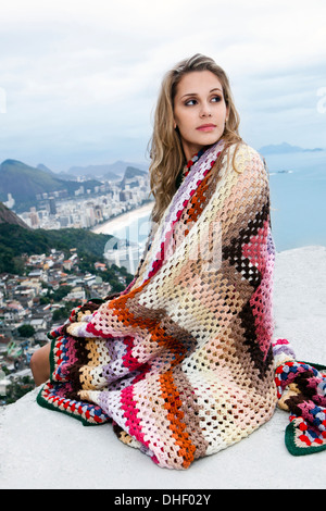 Mujer joven envuelto en la manta de lana, Casa Alto Vidigal, Río de Janeiro, Brasil Foto de stock