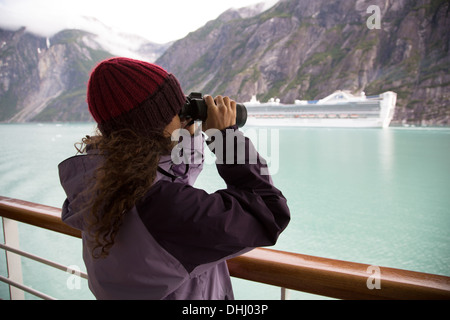 Mujer con los binoculares en crucero, Ketchikan, Alaska, EE.UU. Foto de stock