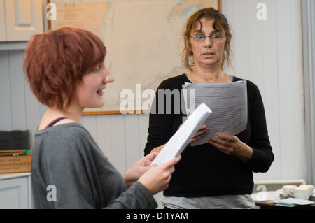 Dos mujeres amateur actores leyendo sus scripts en un ensayo para una obra de teatro UK Foto de stock