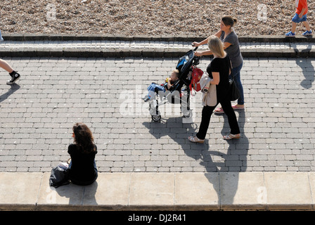 Brighton, East Sussex, Inglaterra, Reino Unido. Las mujeres empujando el cochecito de niños a lo largo del paseo marítimo Foto de stock