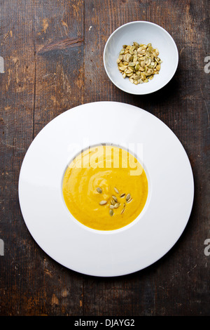Sopa de calabaza con semillas de calabaza sobre fondo de madera