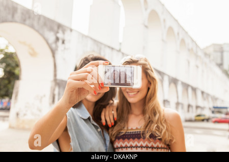 Las mujeres jóvenes teniendo autorretrato fotografía delante del Acueducto Carioca, Río de Janeiro, Brasil Foto de stock