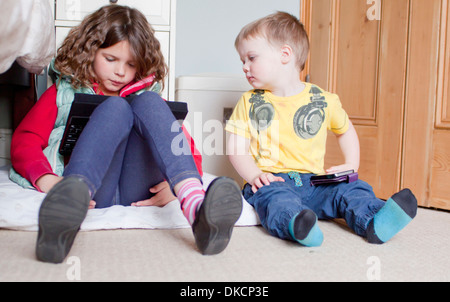 Los niños con digital tablet y teléfono móvil
