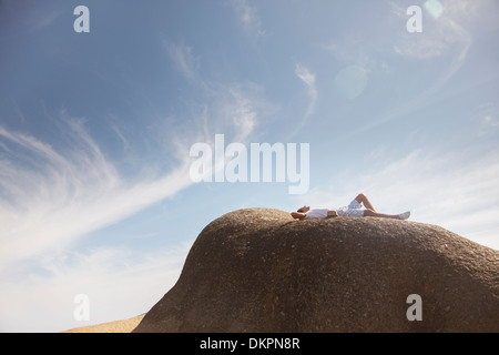 Hombre relajante sobre formación de roca